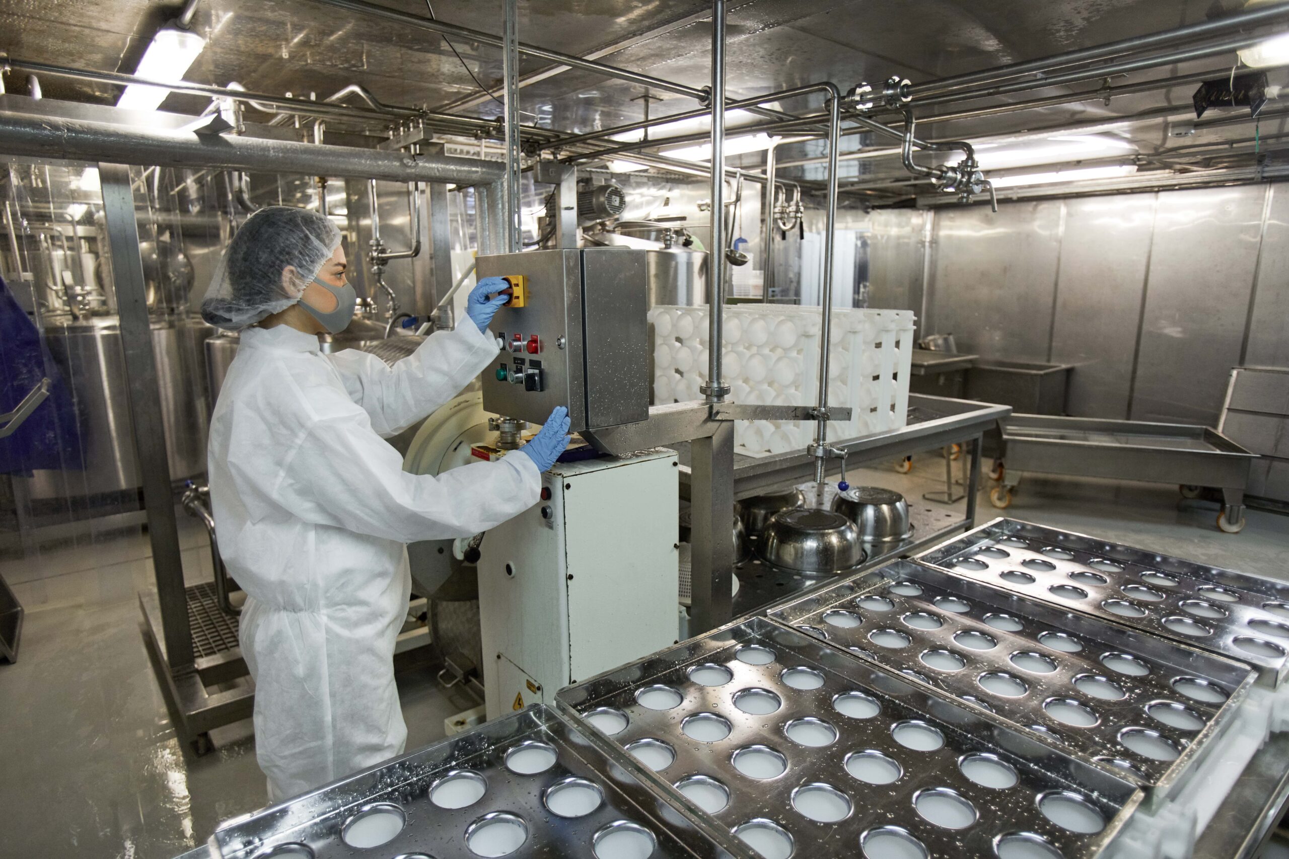 Manufacturing safety pilot program: Food production facility worker in protective equipment using predictive safety technology on production line